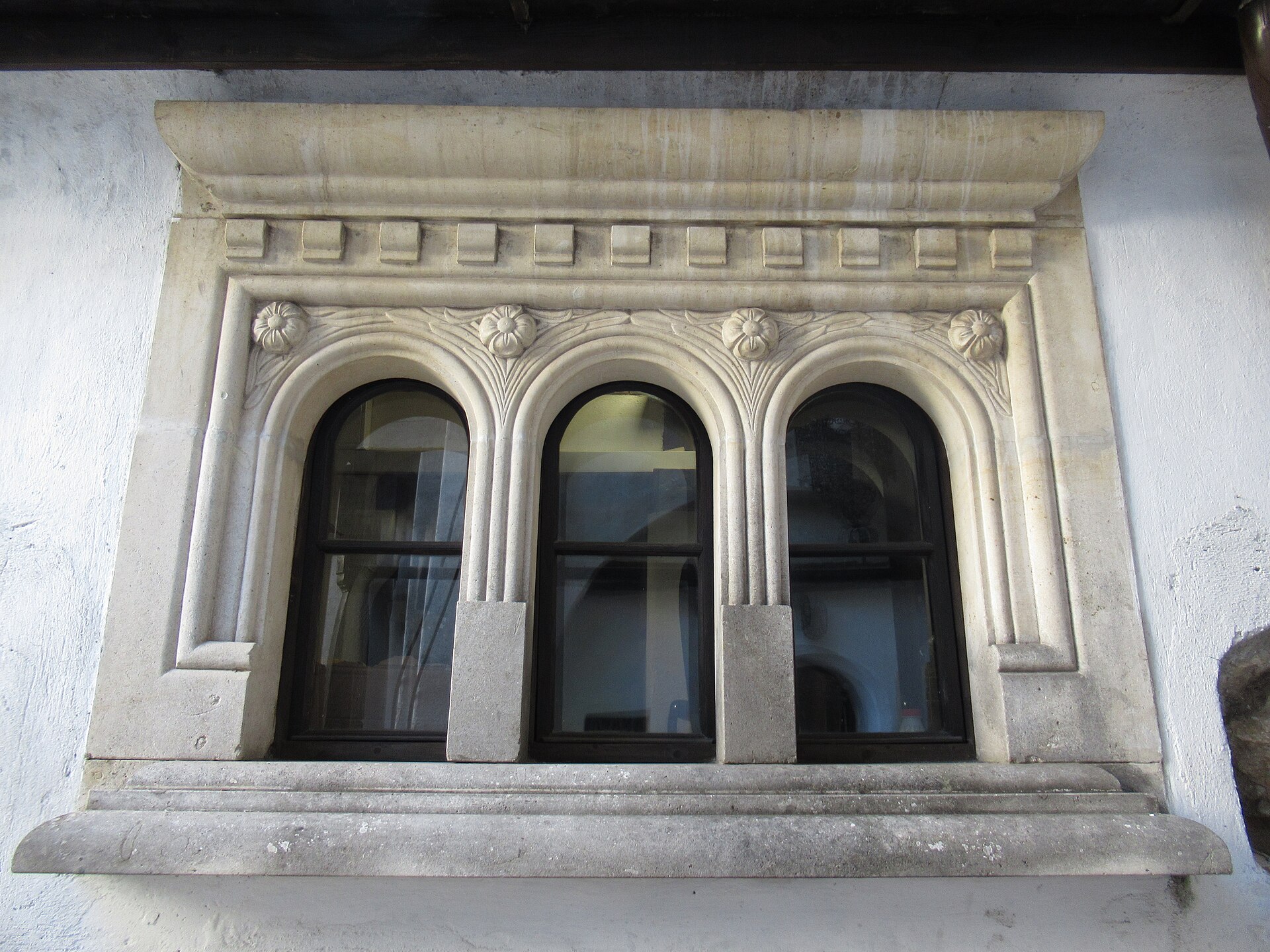 Ancadramentul sculptat al celor trei ferestre arcuite.