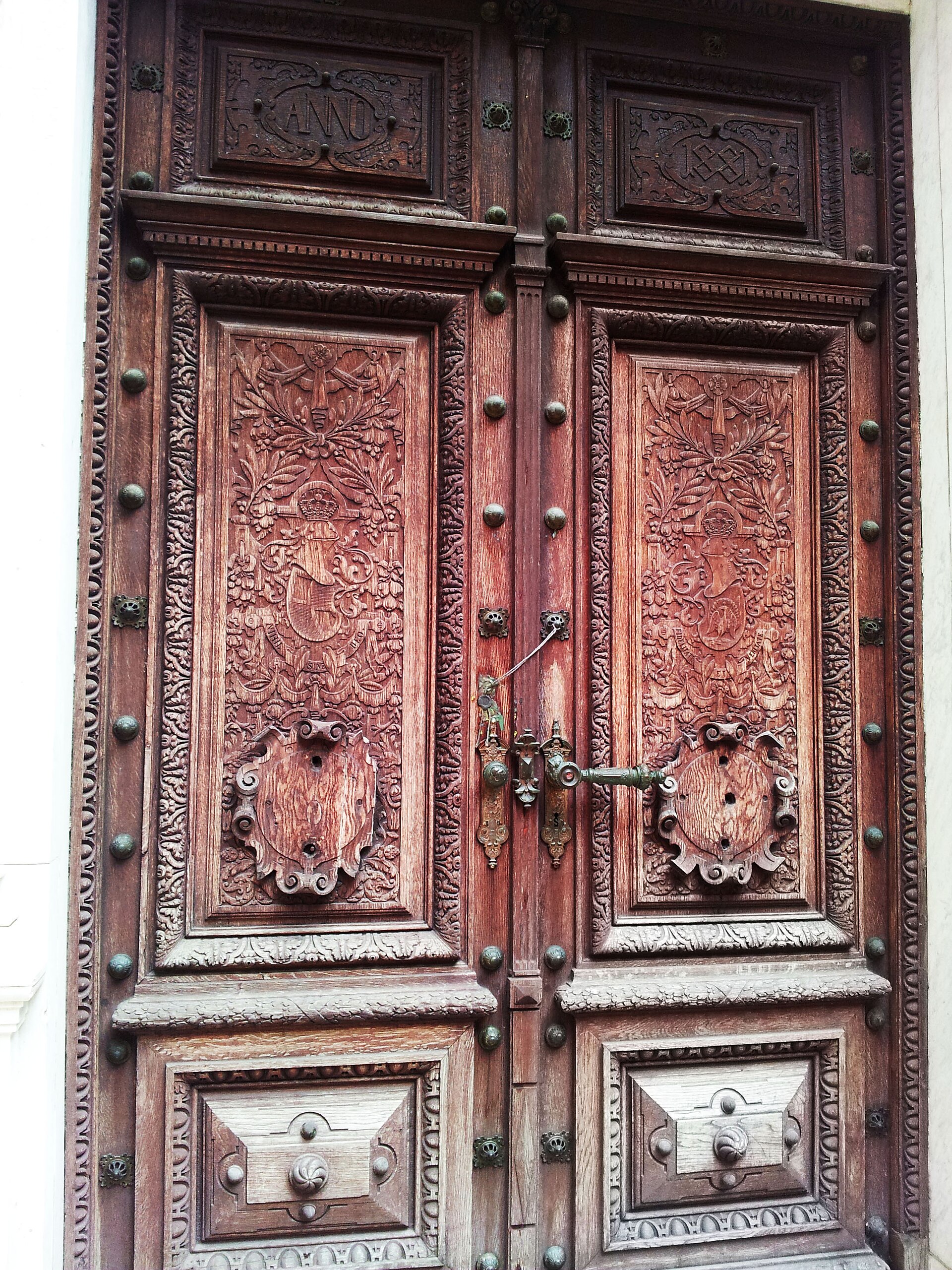 Ușă dublă exterioară cu panouri sculptate și ancadrament.