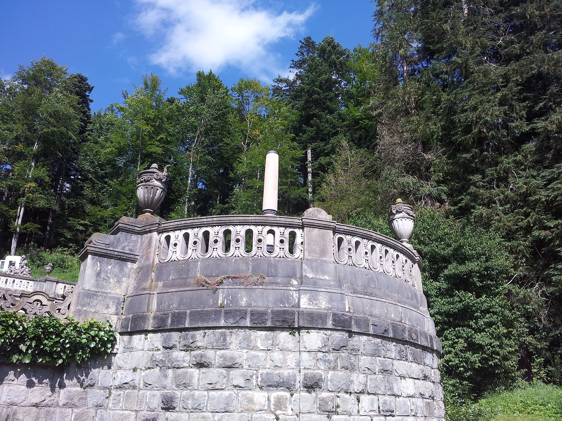 Terasa curbată cu scări și balustradă, privită din grădină.