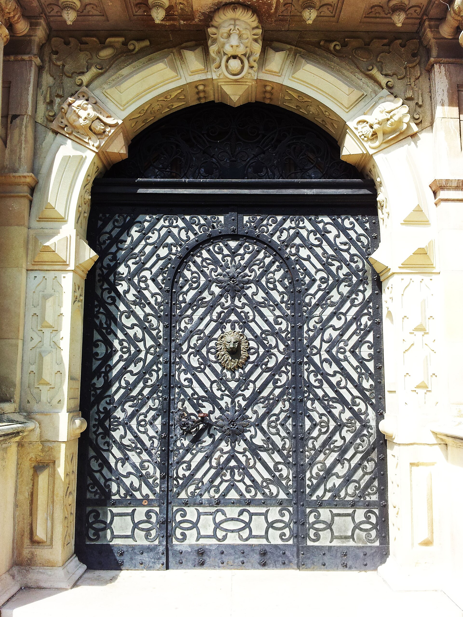 Portal cu arc, coloane laterale și poartă cu grilaj.