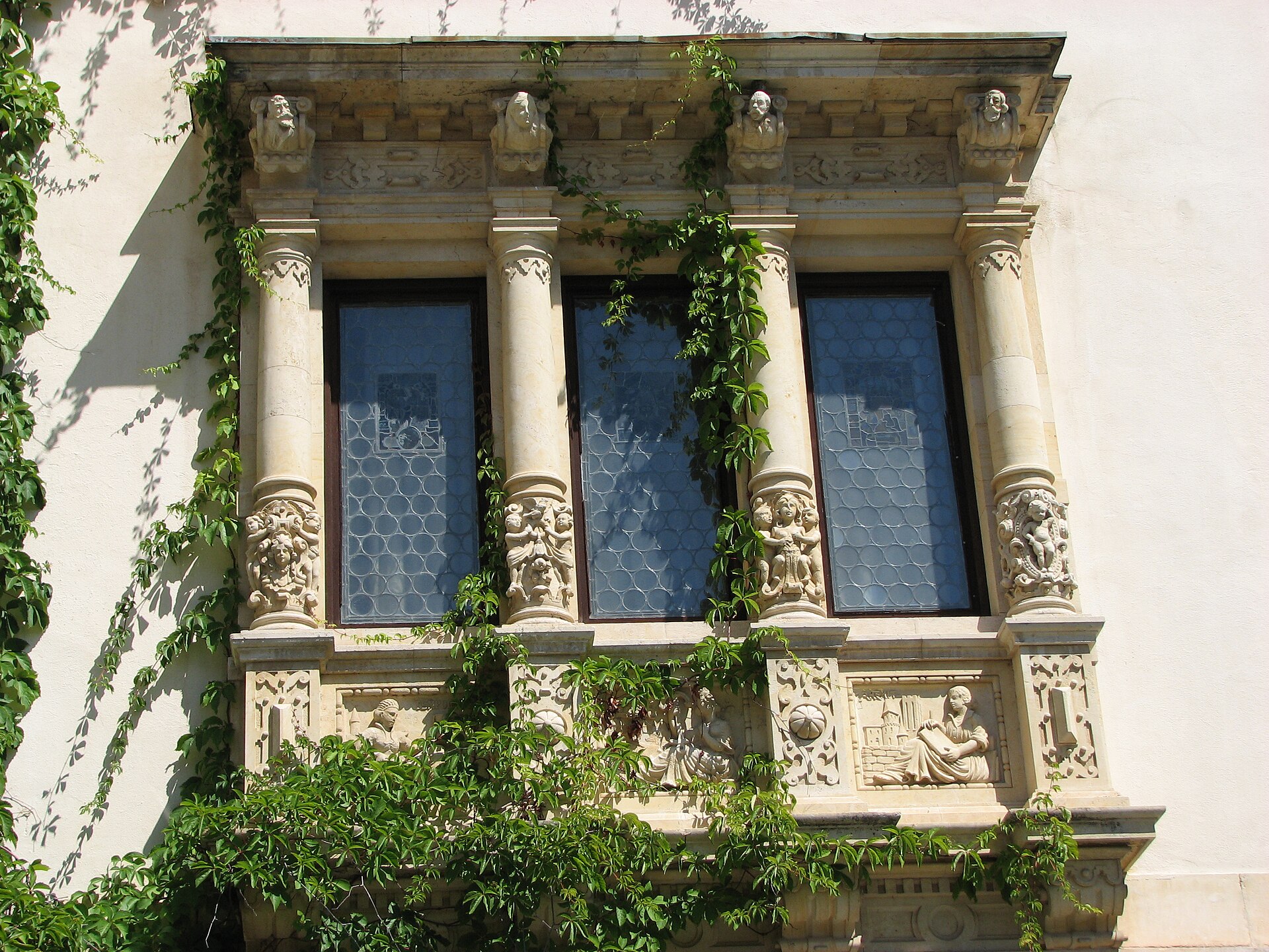 Pereche de ferestre și balcon de piatră decorat.