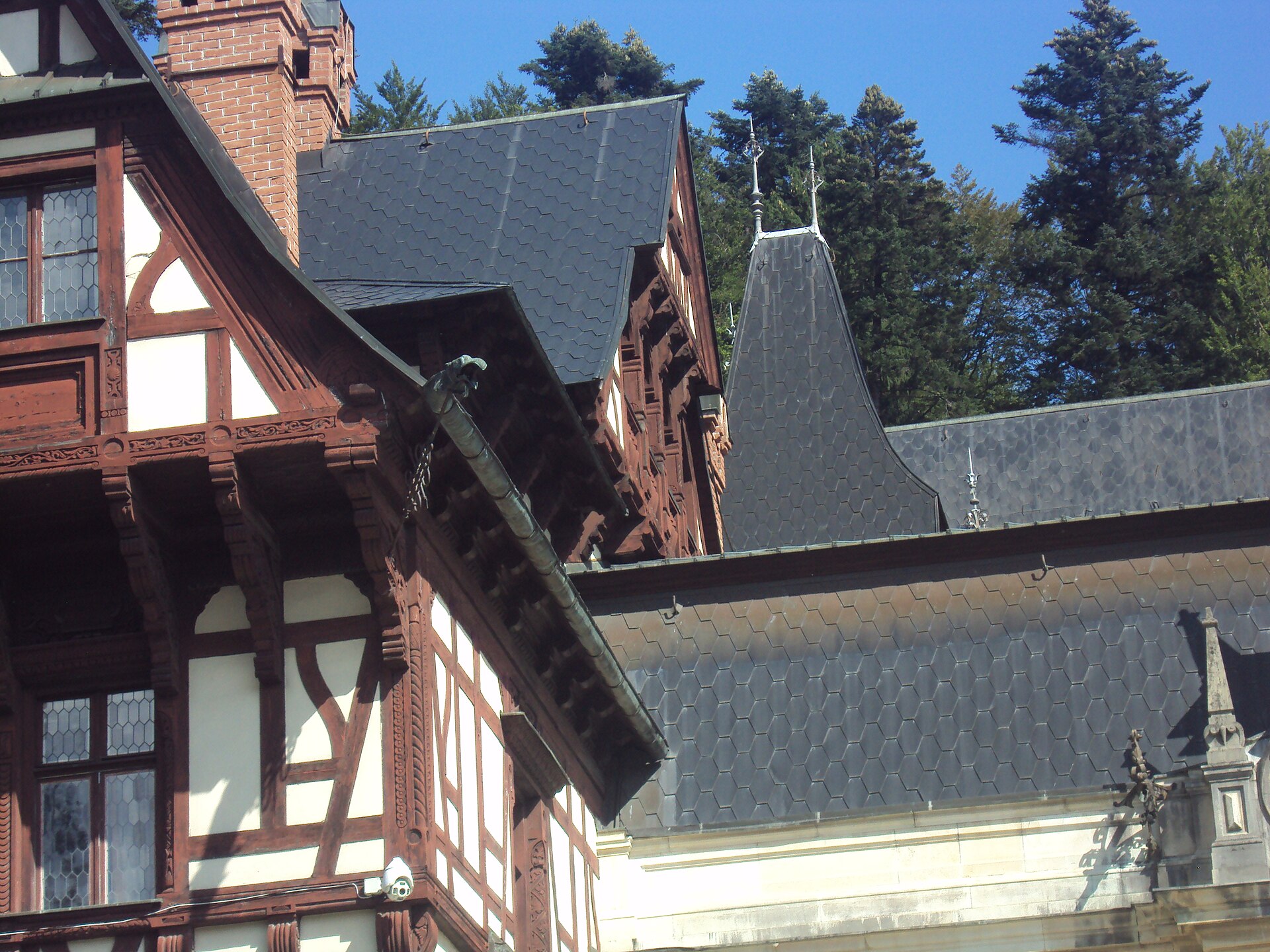 Racord de acoperișuri, fronton de lemn și șarpantă laterală, privite de jos.
