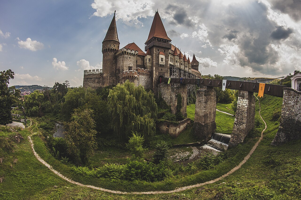 Vedere panoramică din zona de jos, cu podul pe piloni și amplasarea pe stâncă.