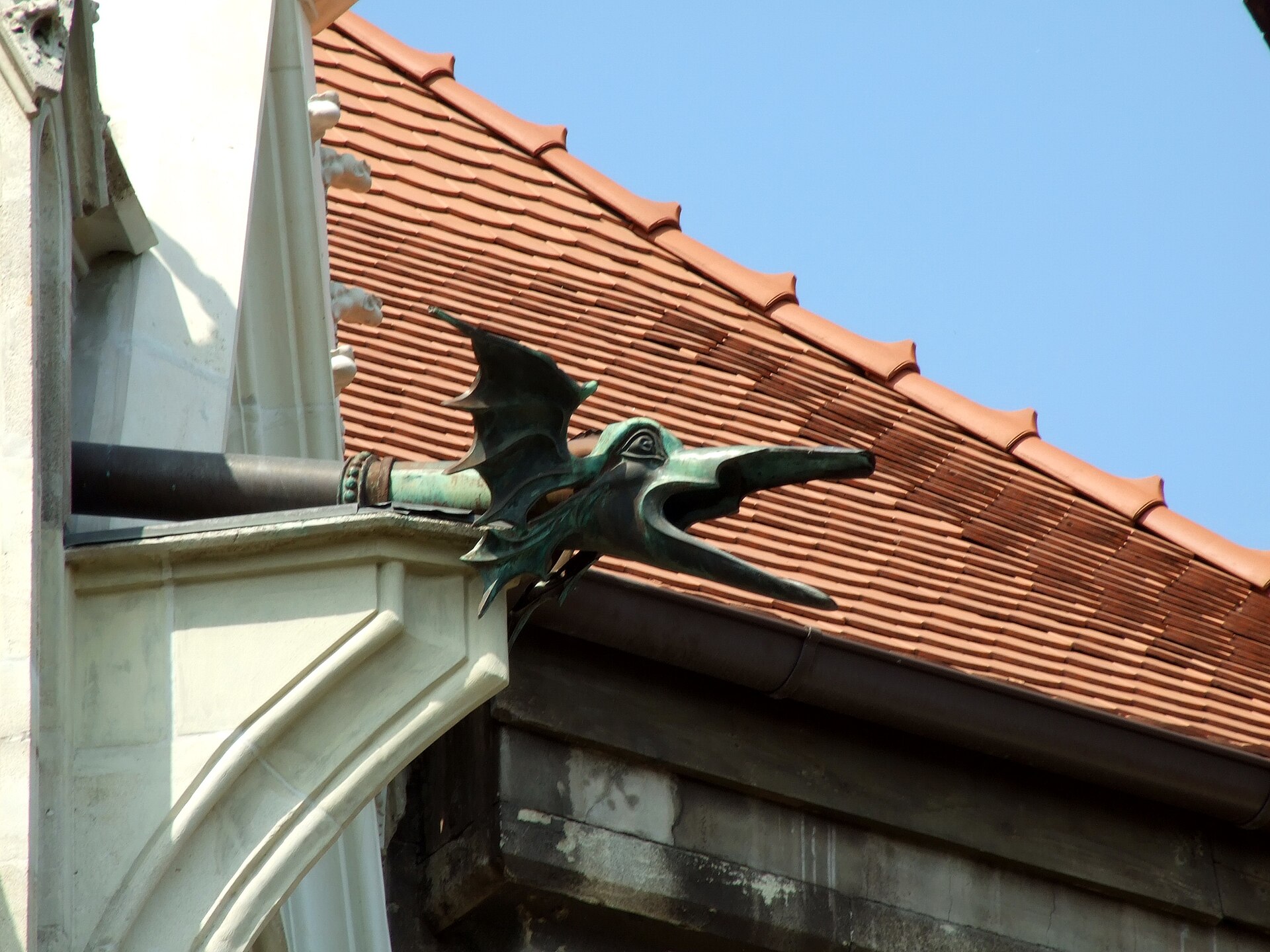 Detaliu al streșinii, țiglelor și pieselor de piatră sculptată ale frontonului.