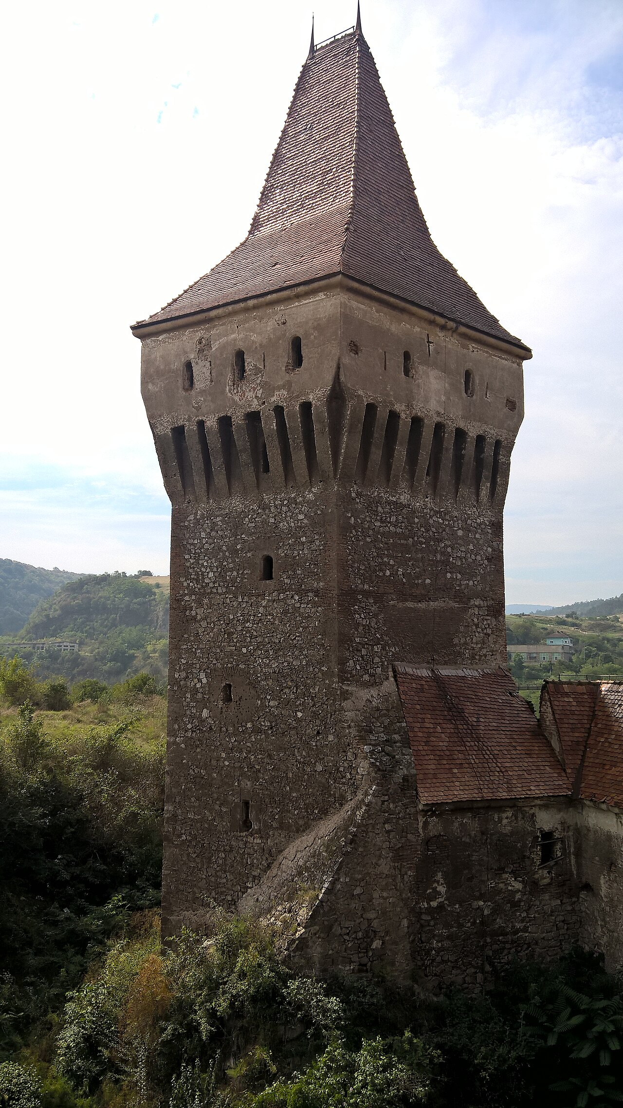 Turnul Nje Boisia văzut oblic din exterior: volum dreptunghiular, coronament și acoperiș.