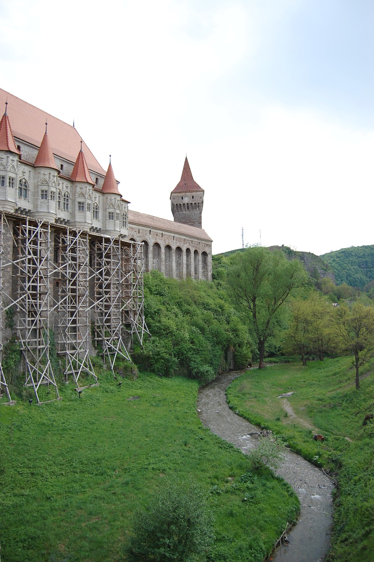 Fațada lungă și galeria spre Nje Boisia, cu relația dintre piloni și terenul inferior.