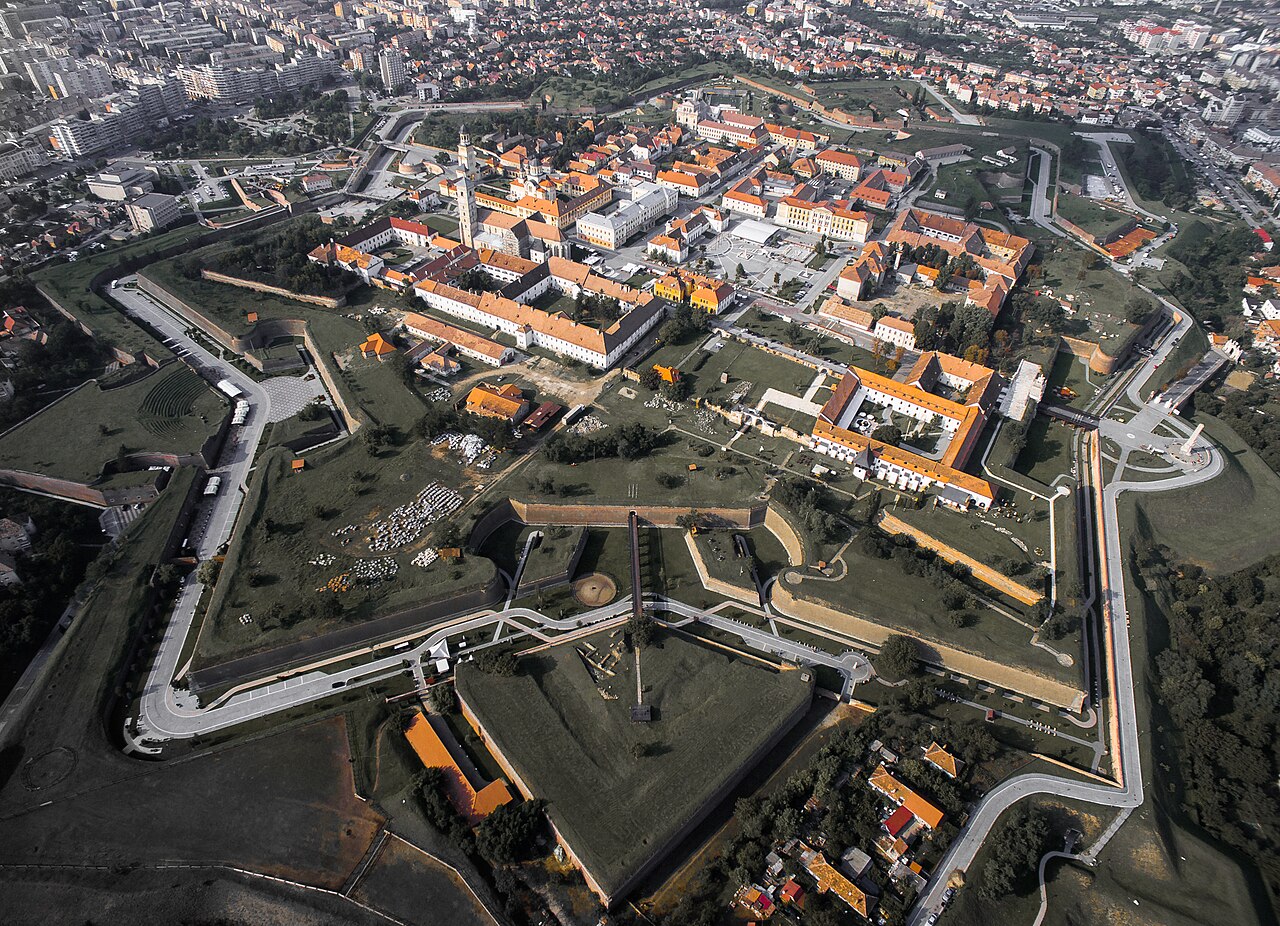 Vedere aeriană oblică a întregii cetăți: bastioane, raveline, șanțuri și relația cu orașul.