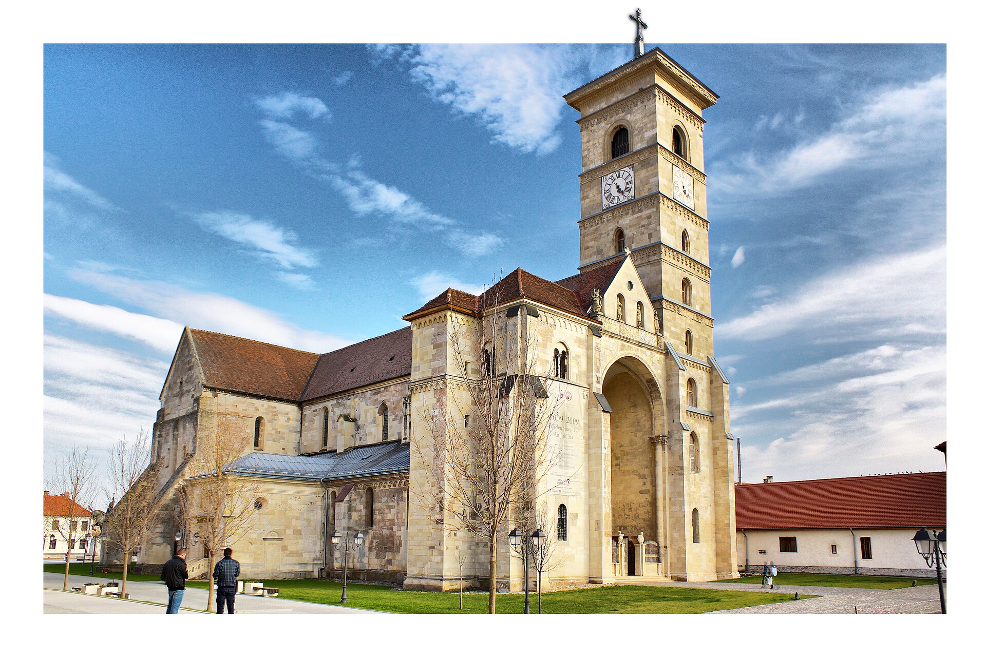 Catedrala romano-catolică privită frontal-oblic: turn, portal și volumele navei.