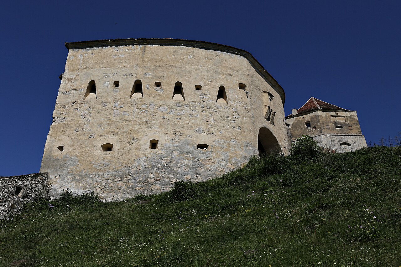 Turnul fortificat și zidurile din apropiere, văzute de la bază.