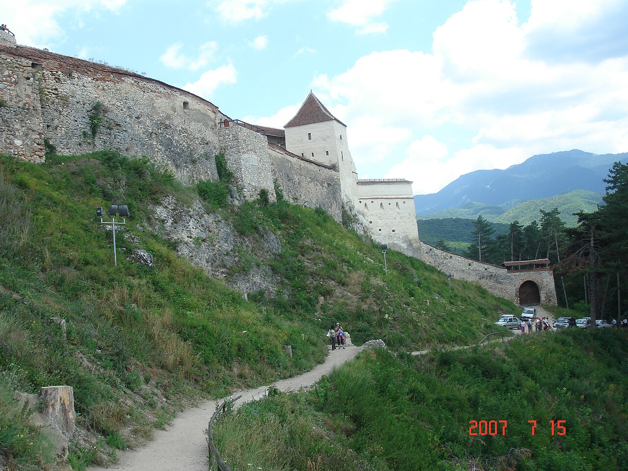 Perspectivă longitudinală pe lângă zidul exterior, turnurile și poteca de pe versant.