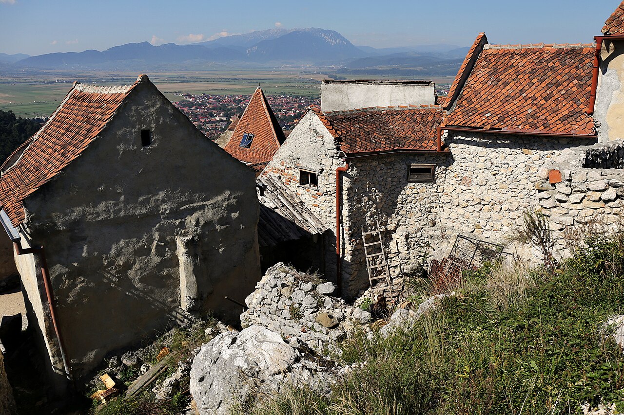 Grupare de case și frontoane din incintă văzute de sus, între ziduri și ruine.
