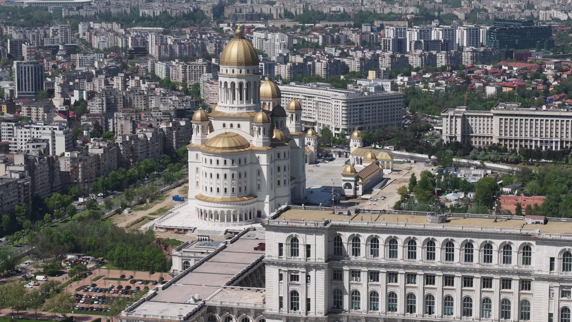 Perspectivă aeriană apropiată asupra corpului cu ferestre arcuite și acoperișurilor-terasă din vecinătatea Catedralei; Catedrala cu cupole aurii este o clădire separată. Imaginea este fotografia-poster furnizată de Pexels pentru videoclip, nu un cadru extras local.