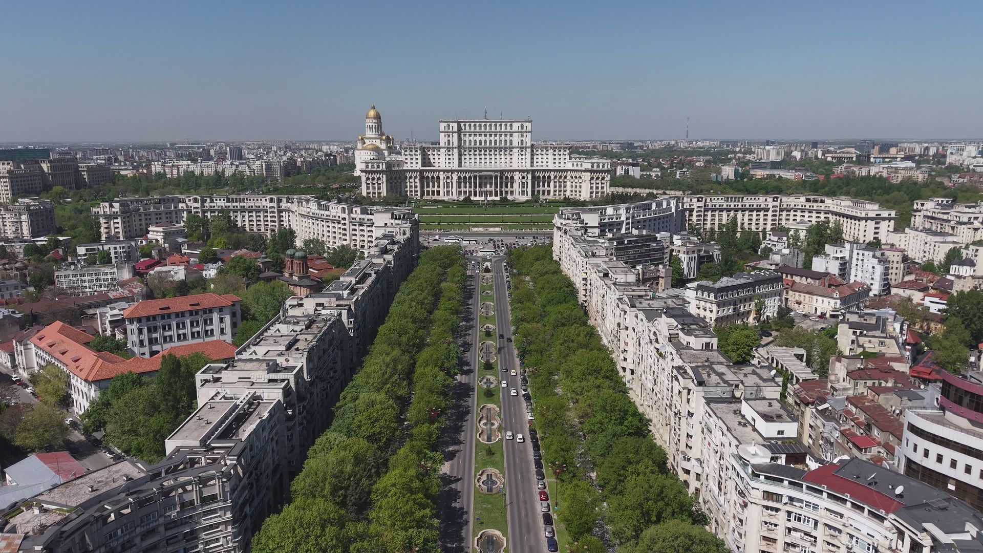 Fațada principală și ansamblul în trepte dintr-o perspectivă aeriană mai înaltă, pe axa bulevardului. Imaginea este fotografia-poster furnizată de Pexels pentru videoclip, nu un cadru extras local.