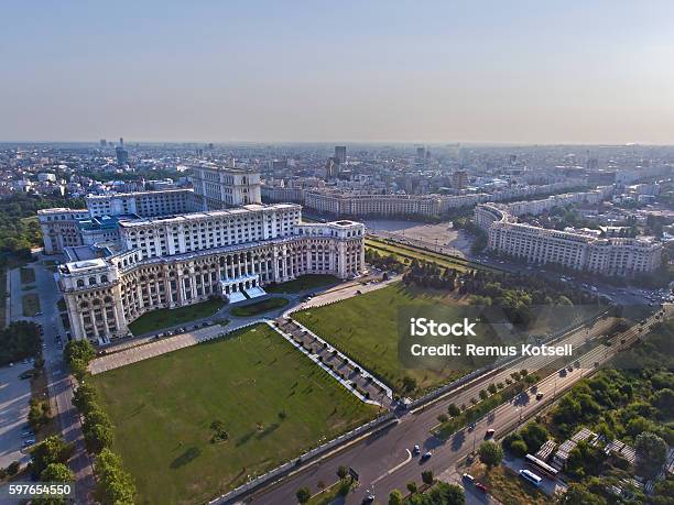 Perspectivă aeriană oblică din colțul opus asupra fațadei cu grădina geometrică, teraselor și volumelor superioare. Previzualizare publică iStock, rezoluție redusă; marcajele sursei sunt păstrate.