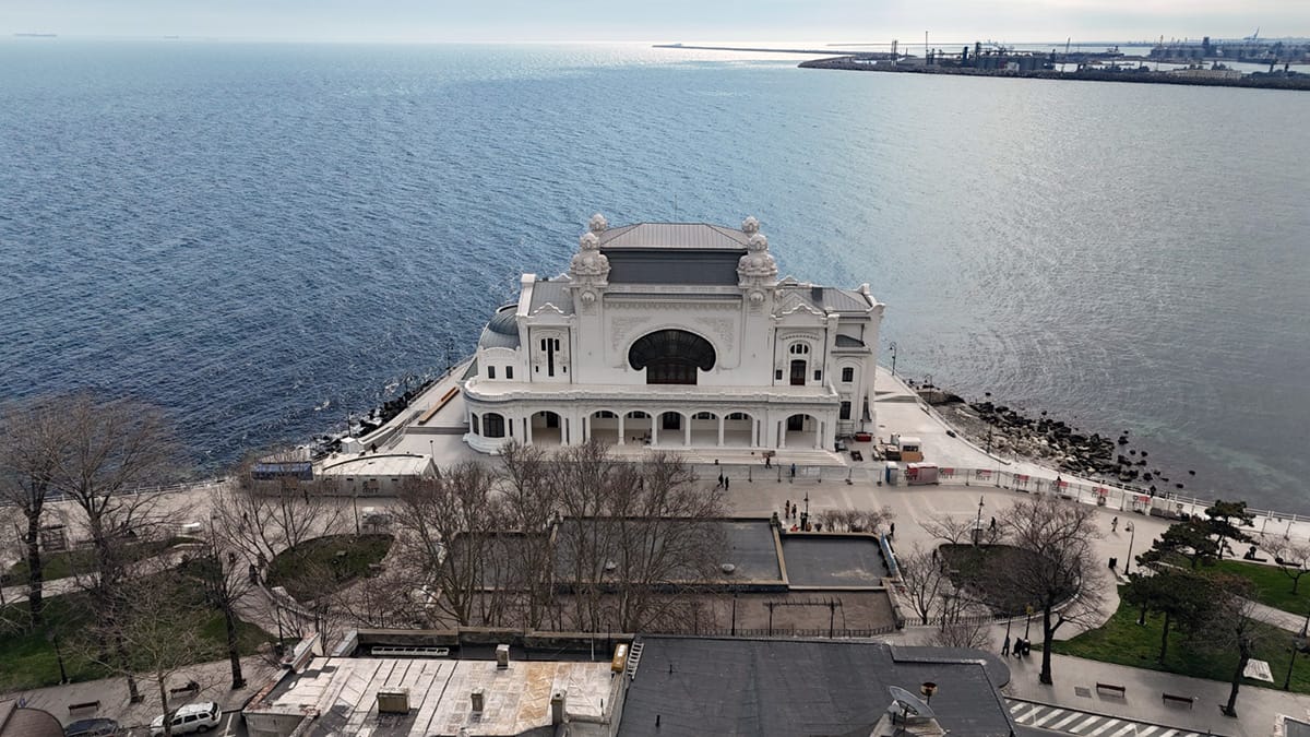 Vedere aeriană frontală spre fațada principală și promenadă; martie 2025