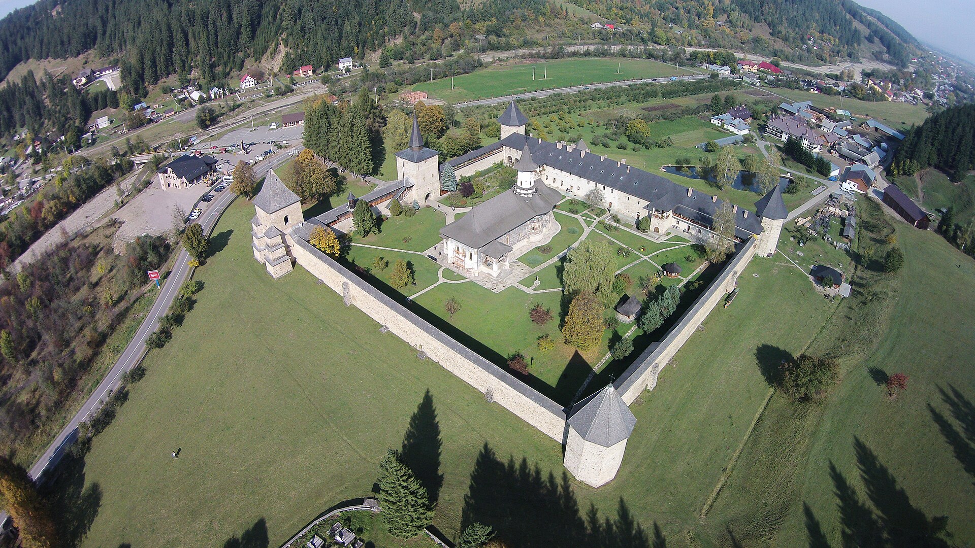 Vedere aeriană oblică: întreaga incintă fortificată, biserica centrală și turnurile de colț