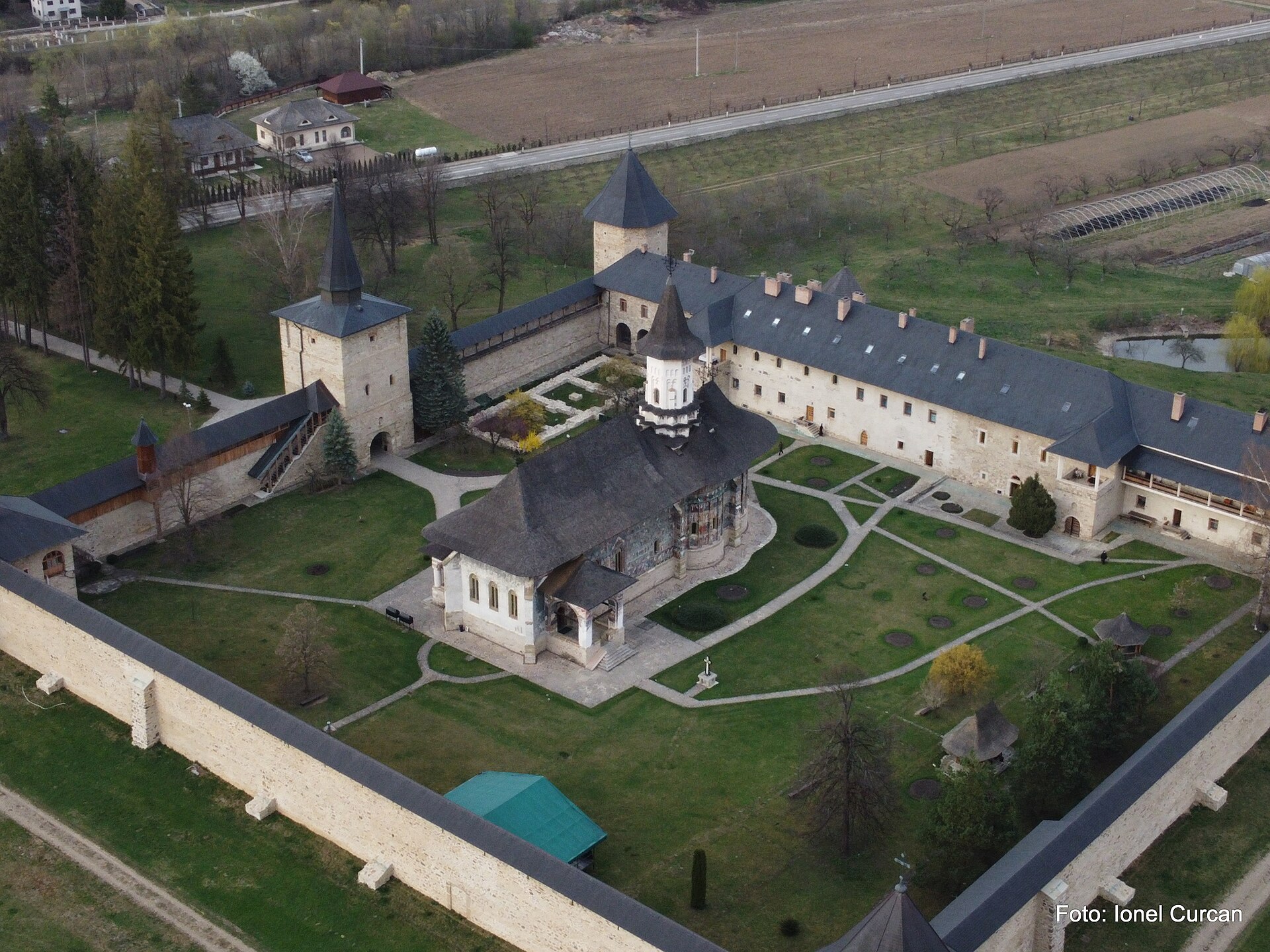 Vedere aeriană mai apropiată: biserică, acoperișuri și corpuri monastice