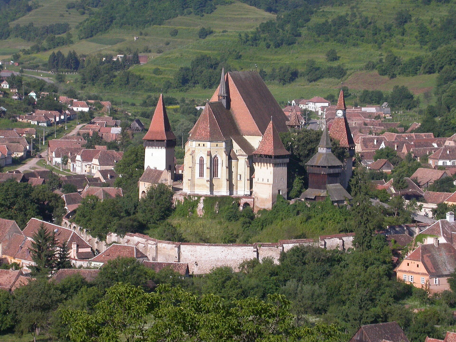 Ansamblu de la înălțime: fațada lungă a bisericii, acoperișurile și zidurile