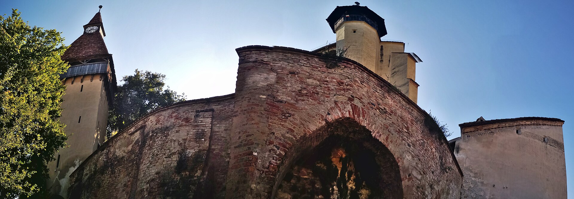 Zid cu arcade și biserica deasupra, perspectivă panoramică joasă