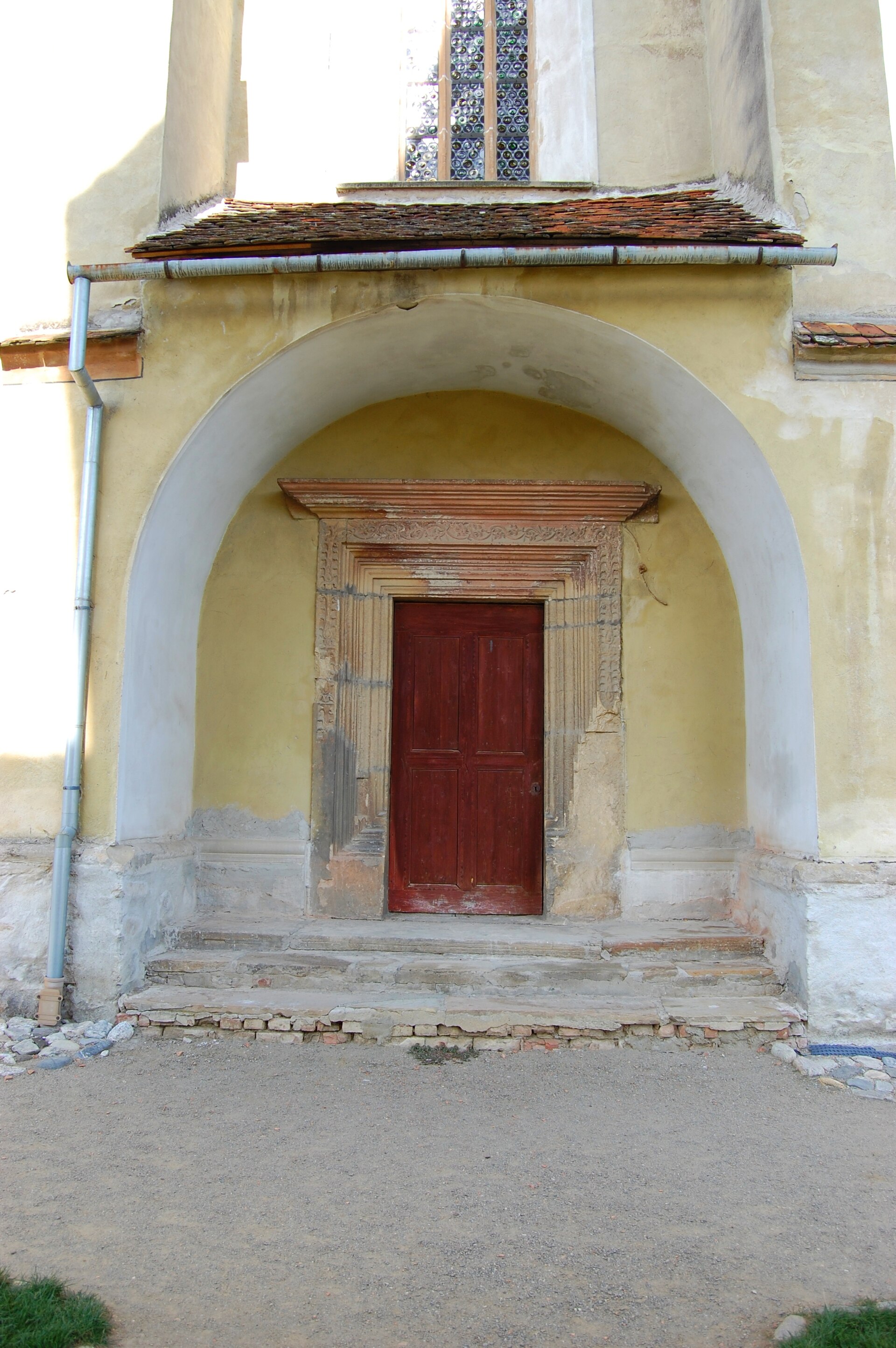 Portal cu ușă și boltă arcuită, ancadrament de piatră și treaptă