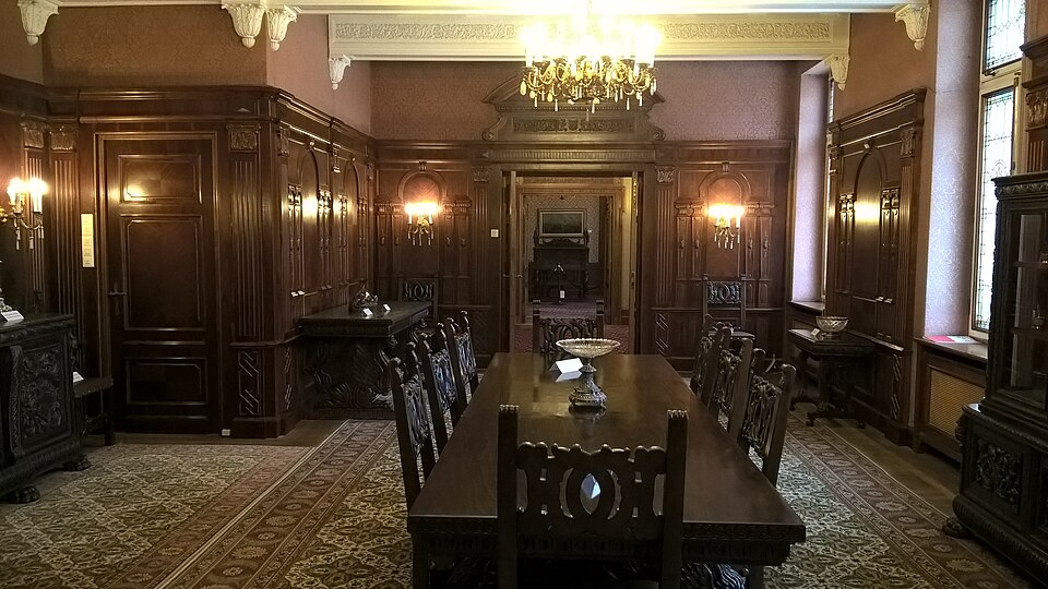 Salon cu lambriuri și mobilier de lemn.