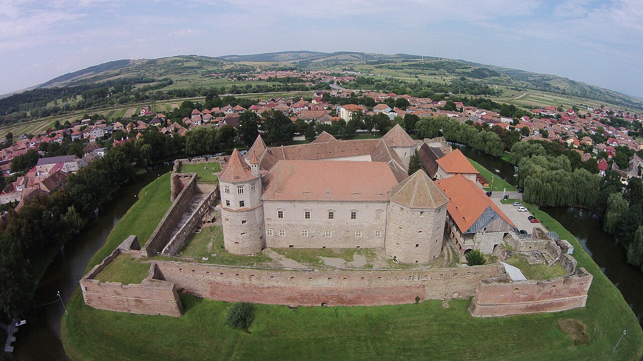 Vedere aeriană oblică: castelul, acoperișurile, bastioanele și șanțul cu apă