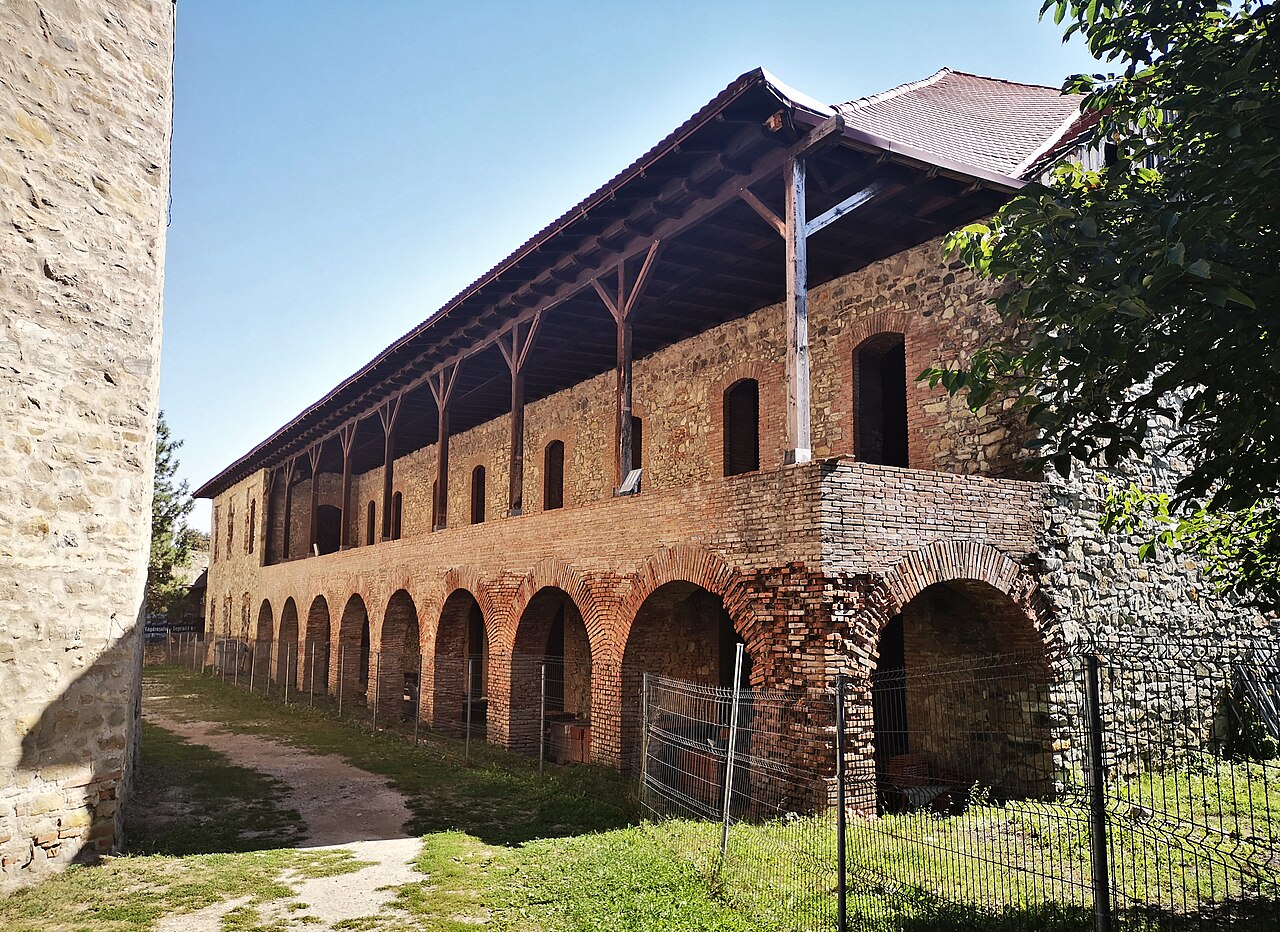 Corp cu arcade la parter, galerie de lemn la etaj și acoperiș în pantă