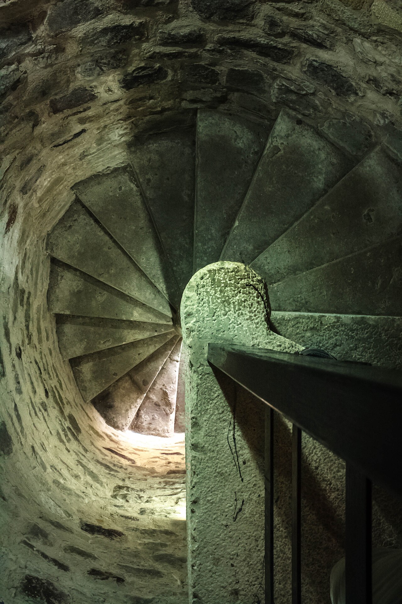 Scară în spirală din piatră, văzută în jos prin deschiderea îngustă