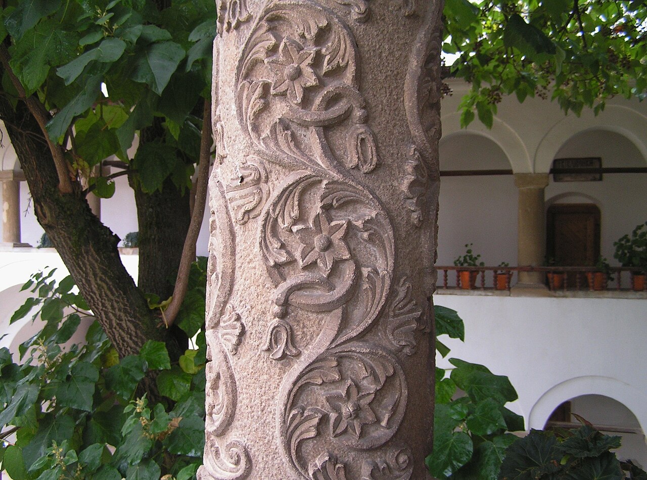 Coloană sculptată a foișorului: decor vegetal și torsadă.