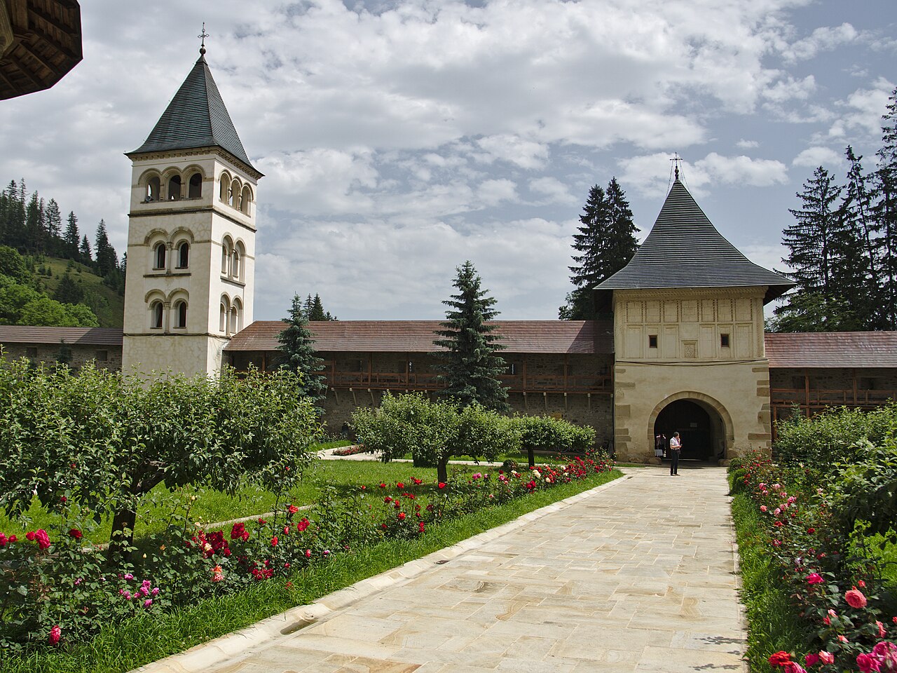 Turnul porții și clopotnița în contextul aleii din curte.