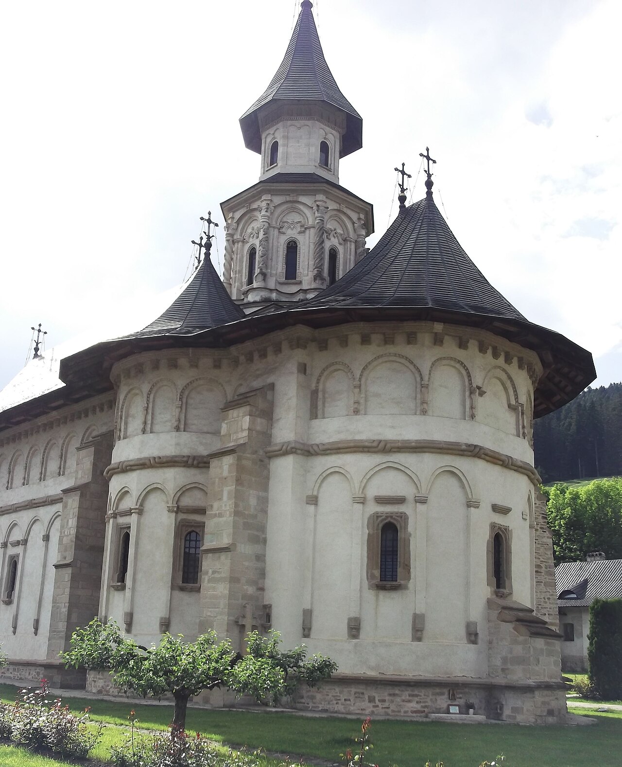 Capătul absidal al bisericii, cu turla și streașina deasupra.