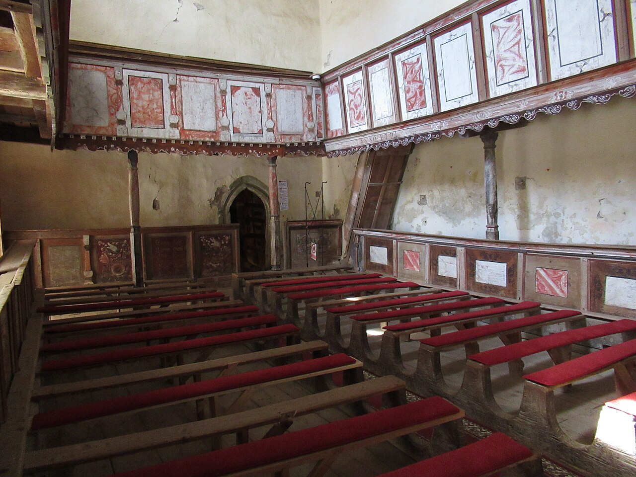 Interiorul din colț, cu galerie laterală și bănci.