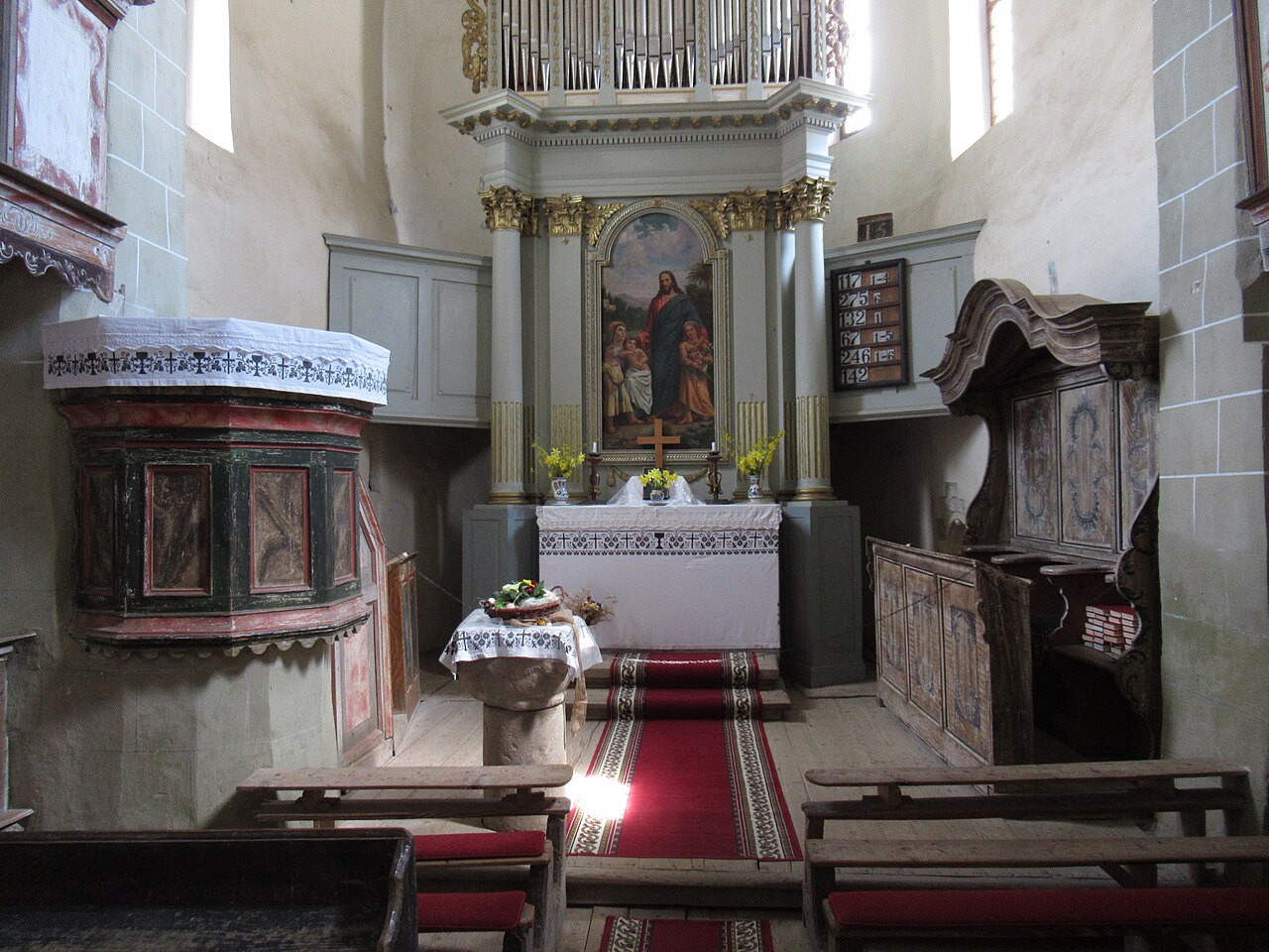 Interior către altar, cu galeriile laterale și mobilier.