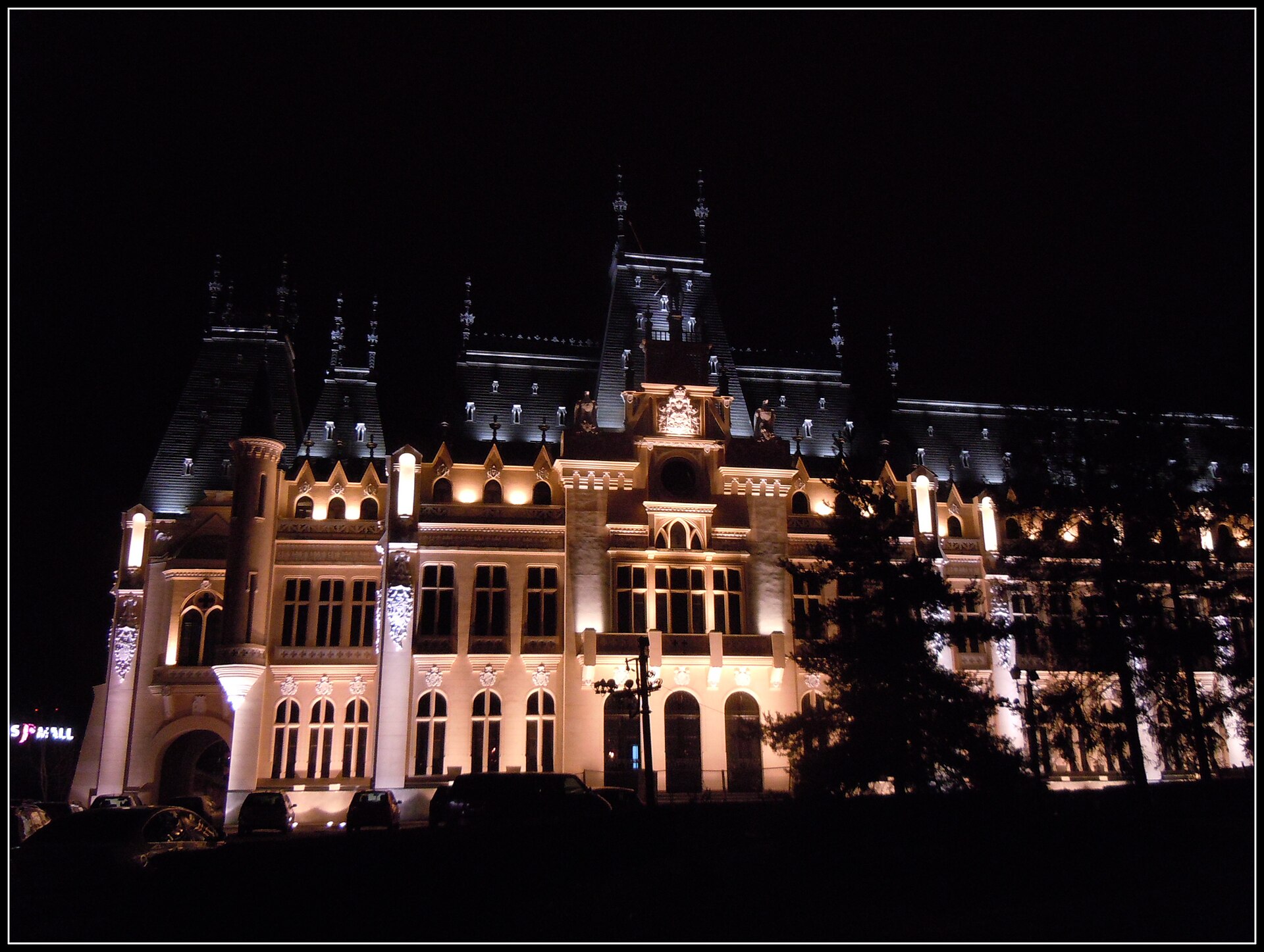 Fațada dinspre Palas iluminată; arborii ascund parțial parterul