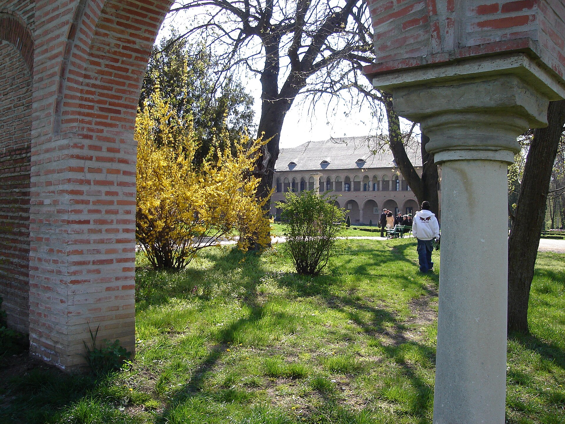 Arcadă de cărămidă și coloană din incintă, cu palatul în fundal