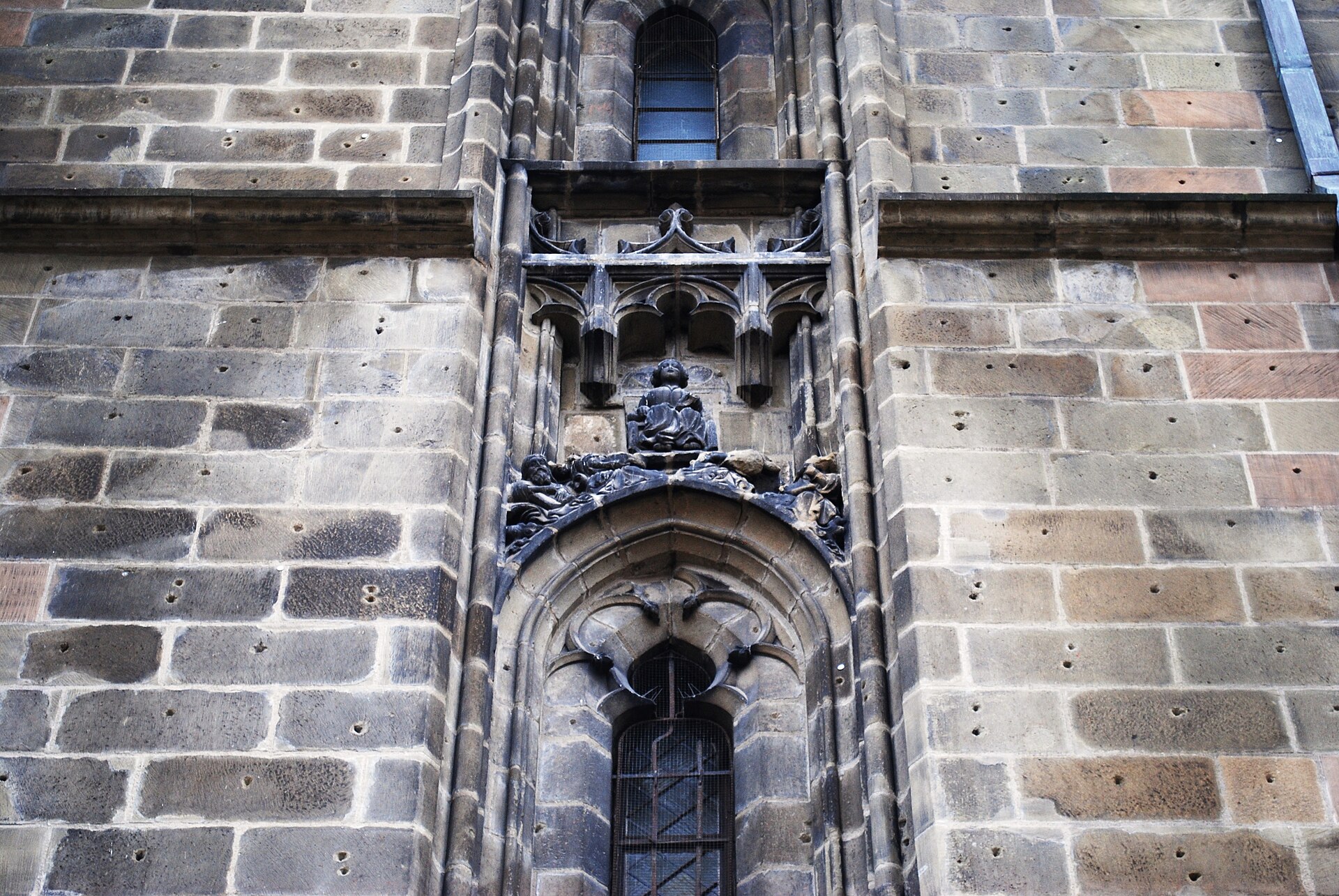 Nișă sculptată și decor gotic pe zidăria exterioară.