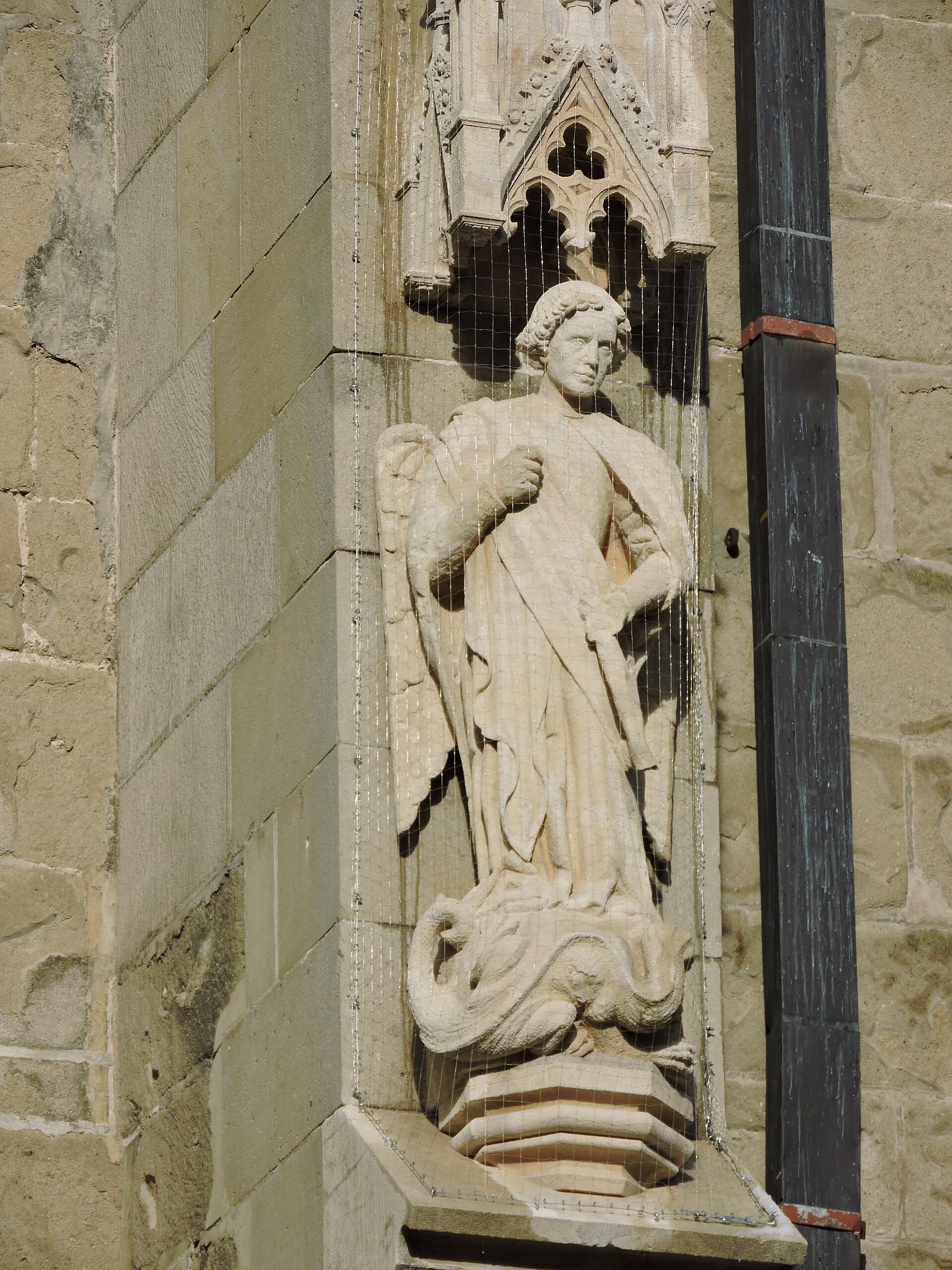 Statuie de piatră într-o nișă gotică, cu baldachin sculptat.
