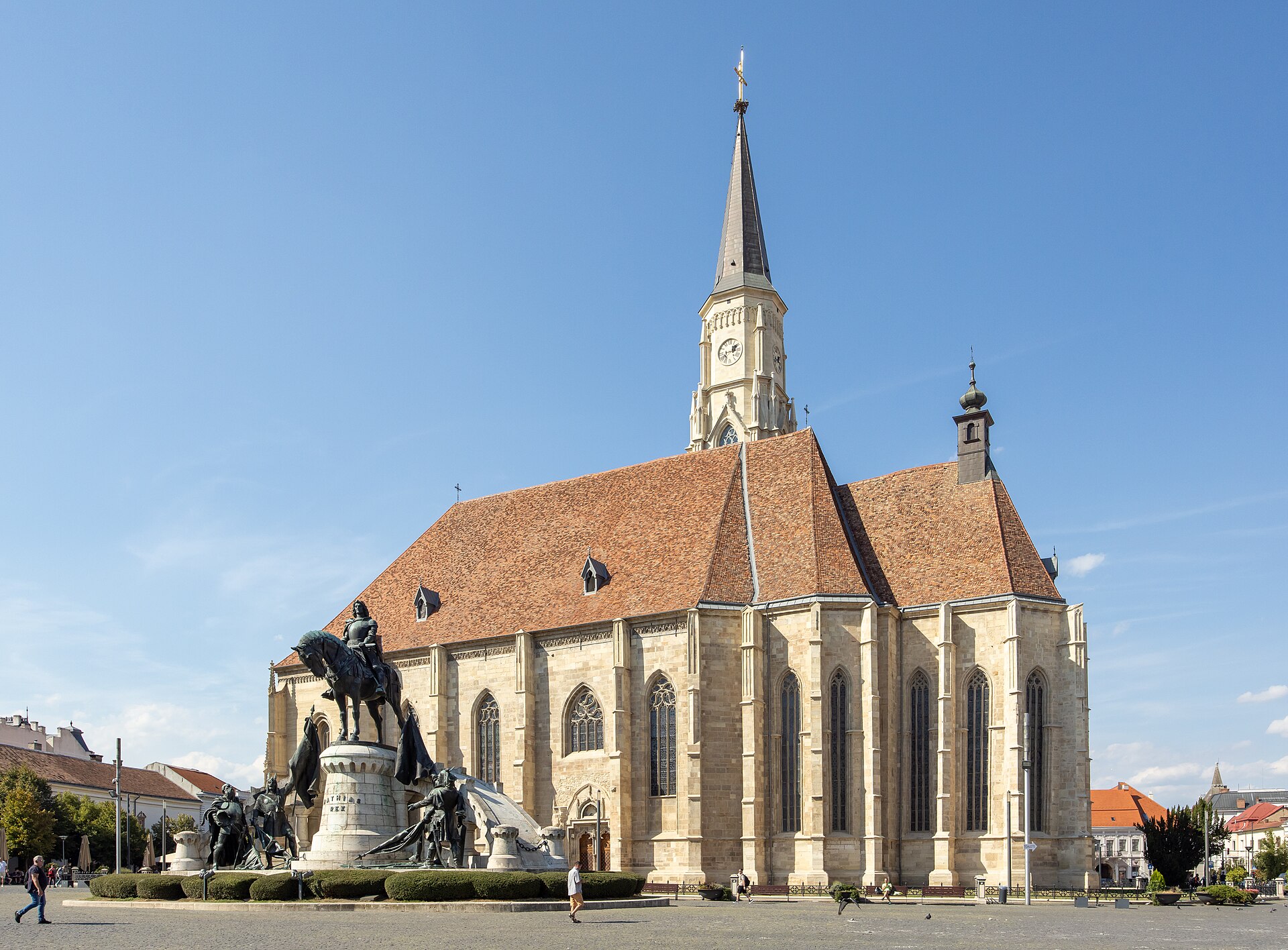 Biserica și turnul neogotic din Piața Unirii: fațada lungă, corul poligonal și învelitoarea.