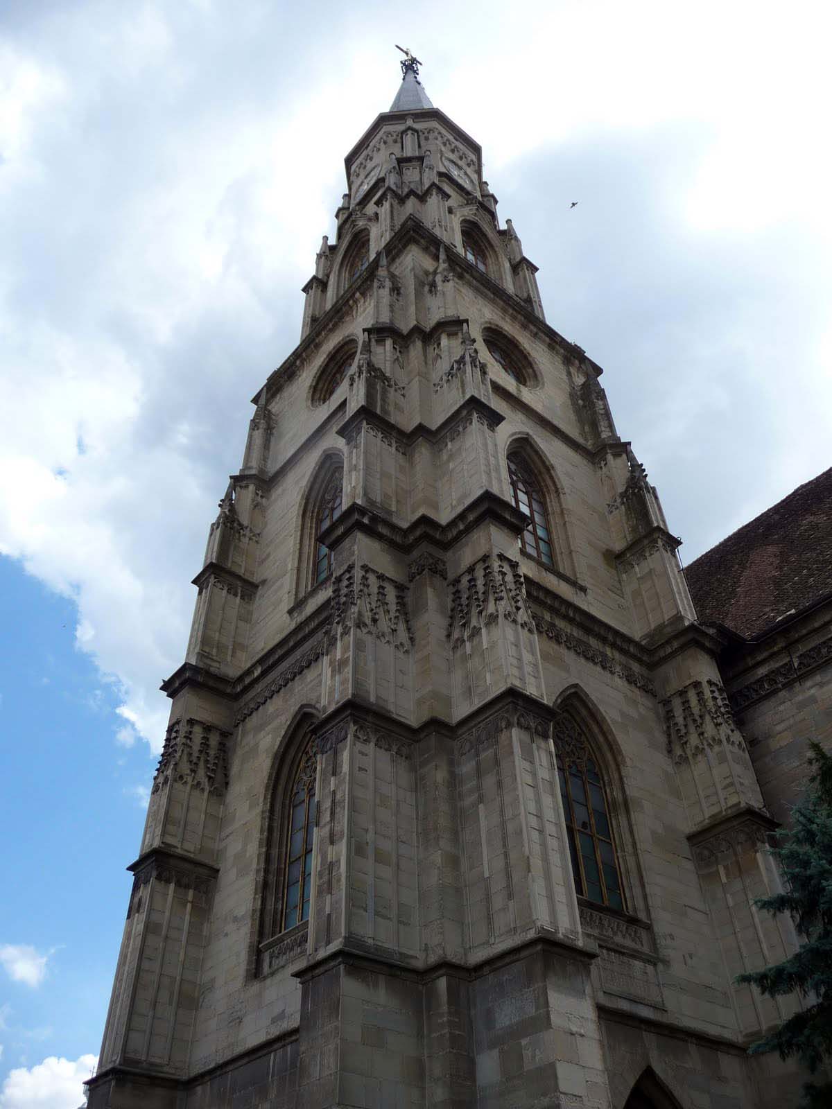 Turnul neogotic privit de la bază în contraplonjeu: etaje, profile și pinacluri.
