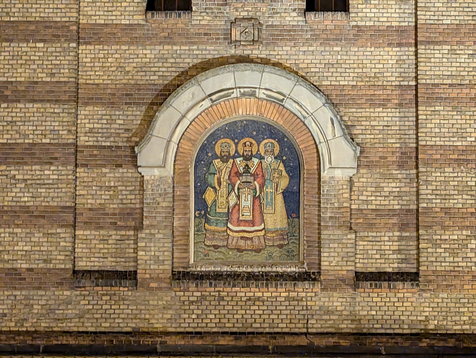 Mozaicul Sfinților Trei Ierarhi, ancadramentul de piatră și cărămida fațadei.