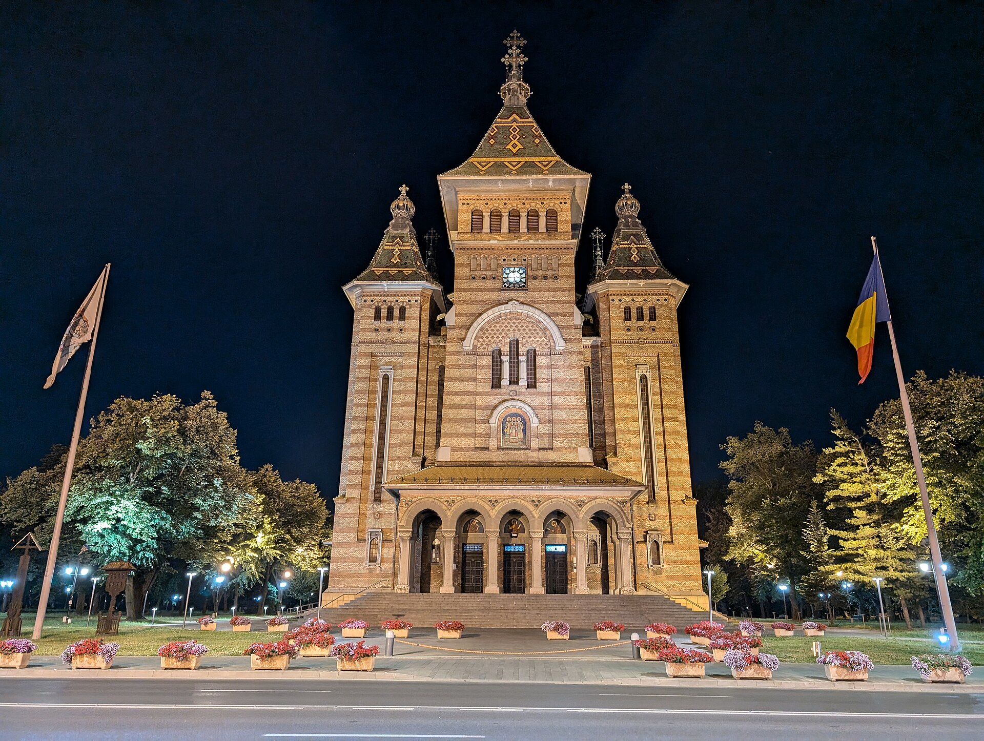 Fațada frontală și pridvorul în iluminare nocturnă; tonurile nu sunt culori etalon.