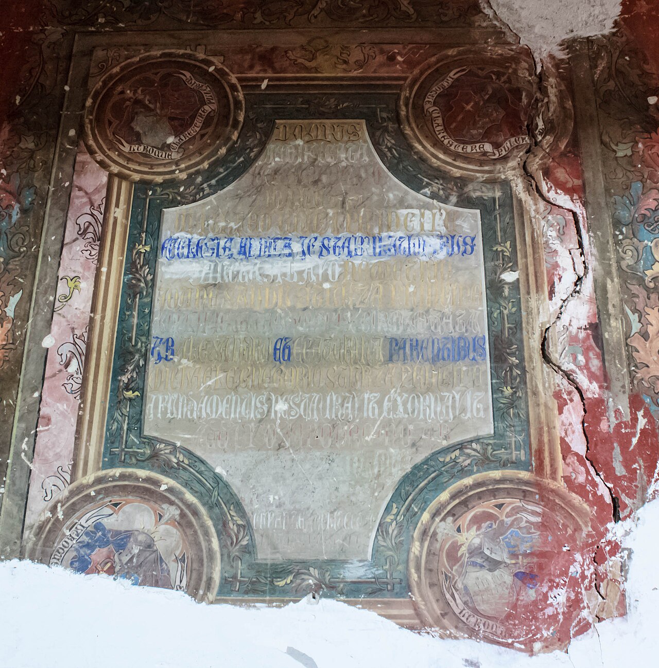 Panou pictat pe tavan cu ramă decorativă și zone deteriorate.