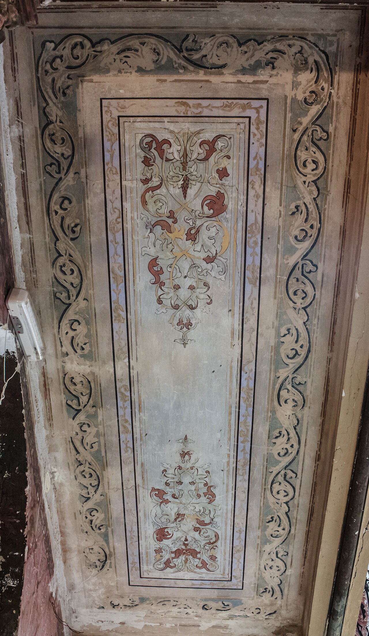 Panou lung de plafon cu ornament floral și profile de stuc.