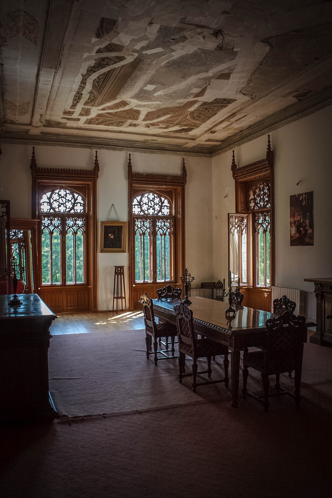 Sală cu mobilier, ferestre și pictura plafonului.