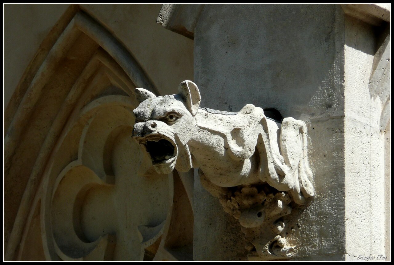 Sculptură zoomorfă pe muchia unui fronton cu arc ogival.
