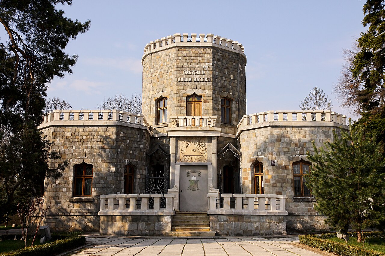 Fațada principală cu trei volume cilindrice, creneluri și portal central, vedere frontală.