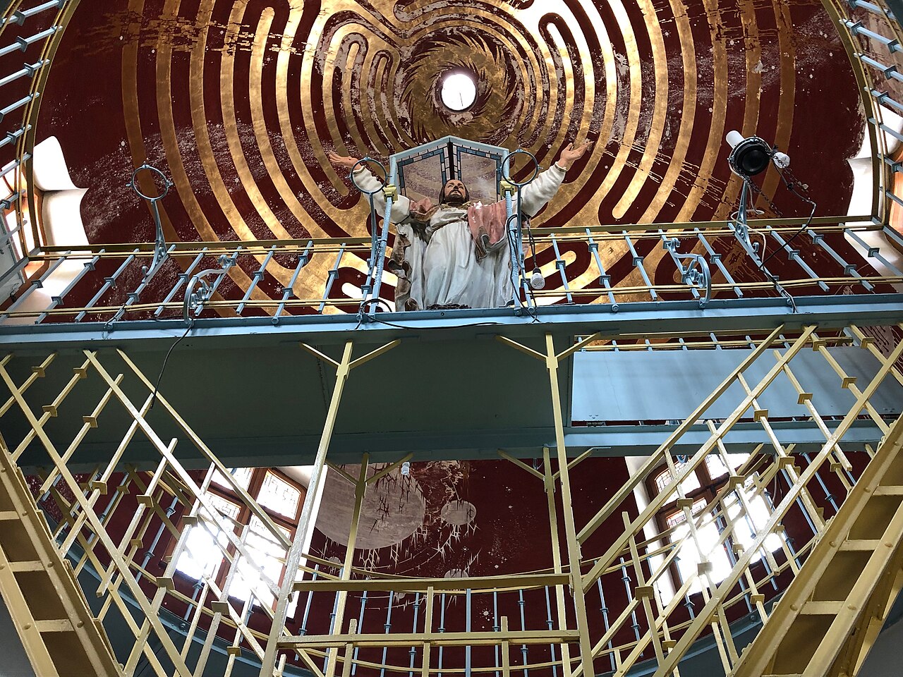 Interiorul turnului-templu: platformă metalică, sculptură și structura circulară a plafonului.