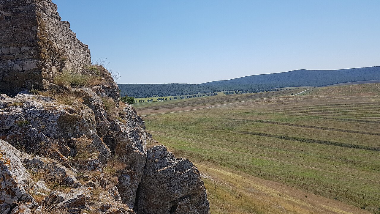 Zid sprijinit pe roca dealului, vedere laterală spre peisaj.