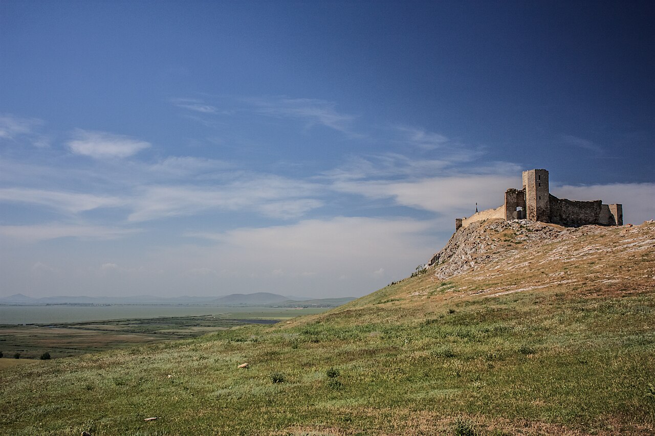 Cetatea și dealul într-o panoramă oblică, cu silueta turnului clară.