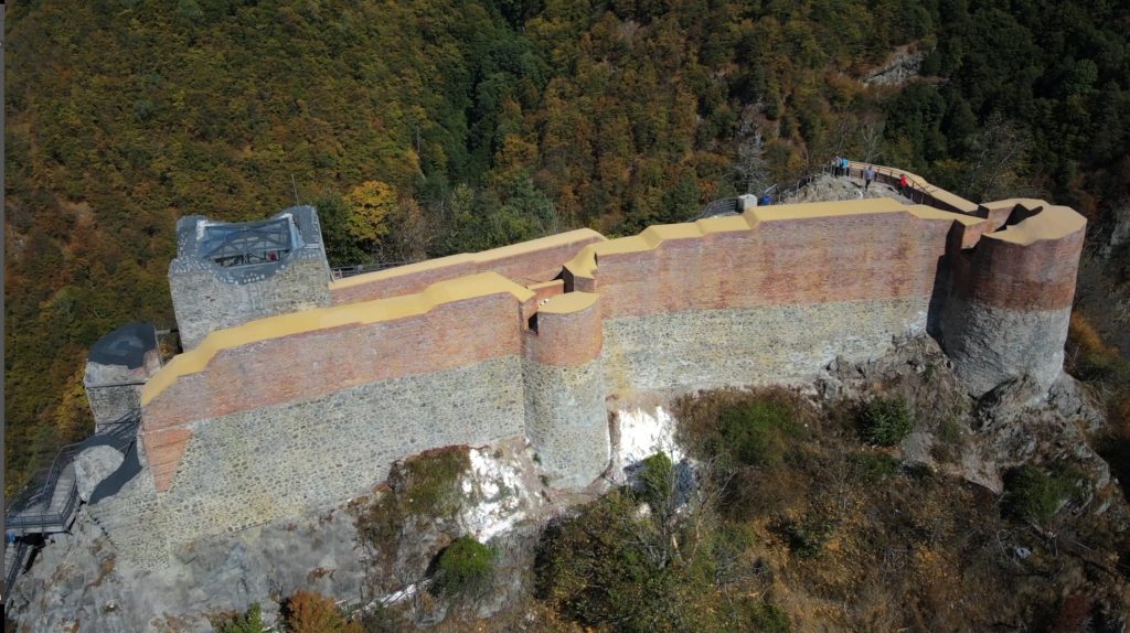 Vedere aeriană laterală a curtinei lungi și turnurilor, în starea cu acoperiri moderne.